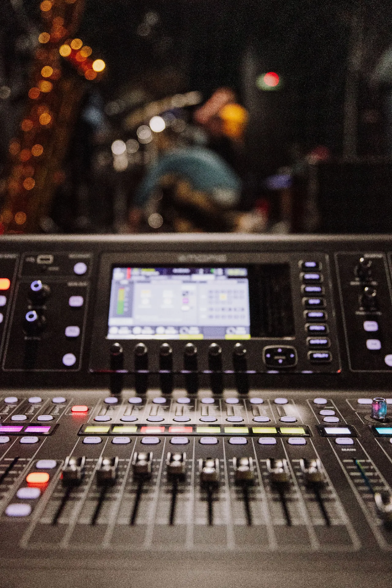 Live console close-up with faders lit